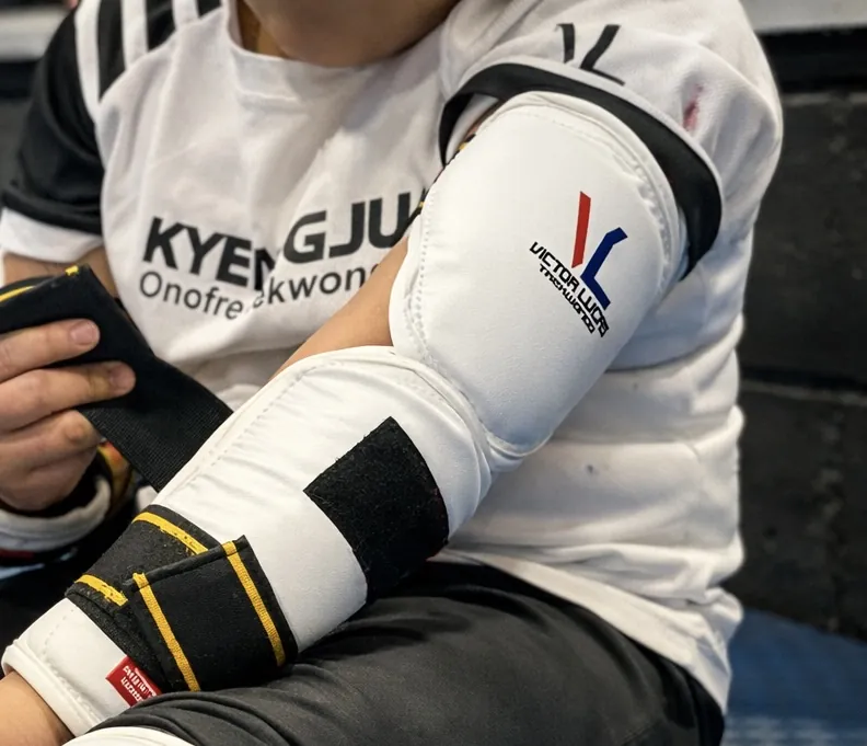 Detalle del uniforme y protecciones con el logotipo de Kyeongju Onofre Taekwondo antes de entrenar.